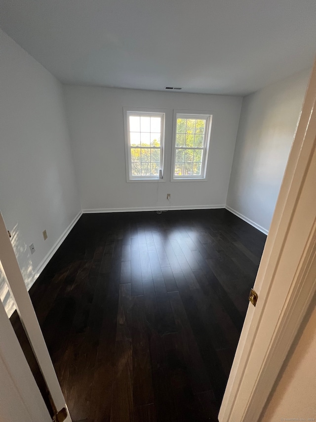 empty room with dark hardwood / wood-style flooring