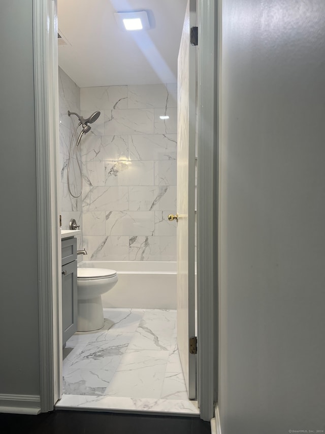 full bathroom featuring vanity, tiled shower / bath, and toilet