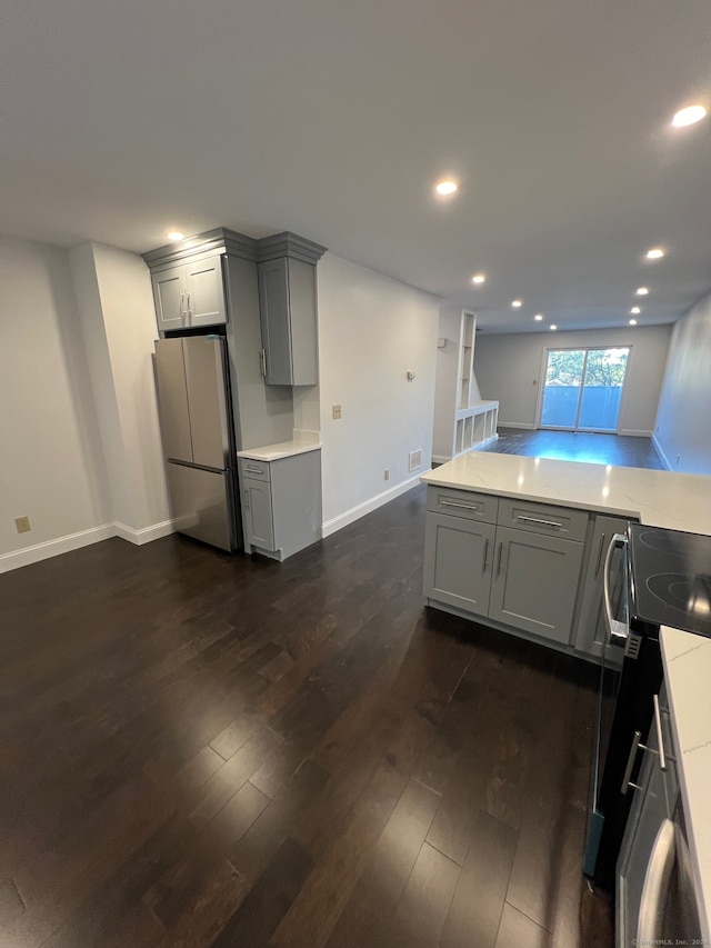 kitchen with gray cabinets, dark wood-type flooring, black stove, and stainless steel refrigerator