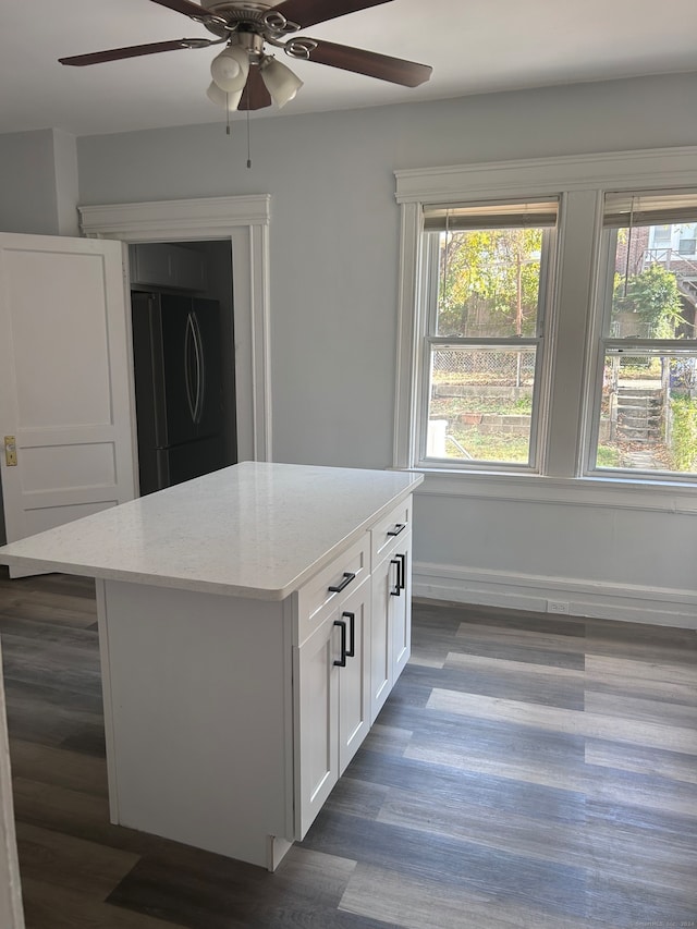 kitchen featuring a wealth of natural light, a kitchen island, and black refrigerator