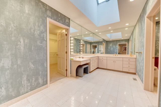 bathroom featuring vanity, a skylight, and tile patterned floors