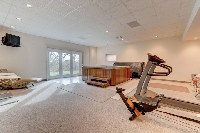 workout room featuring a paneled ceiling, french doors, and light carpet