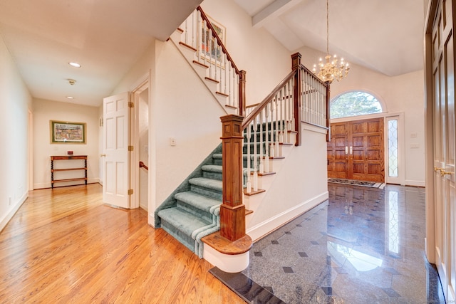 foyer with high vaulted ceiling, hardwood / wood-style flooring, beam ceiling, and an inviting chandelier