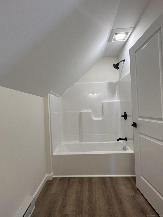 bathroom with hardwood / wood-style flooring, shower / washtub combination, and a baseboard heating unit