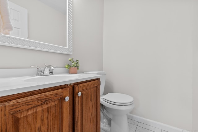 bathroom featuring toilet, vanity, and tile patterned flooring