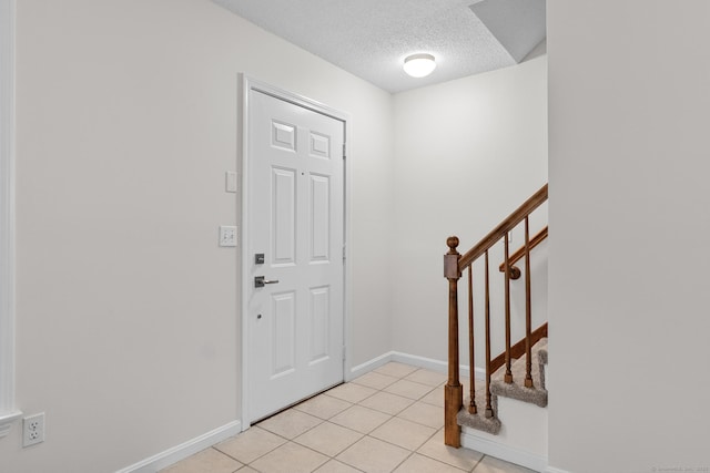 tiled entryway with a textured ceiling