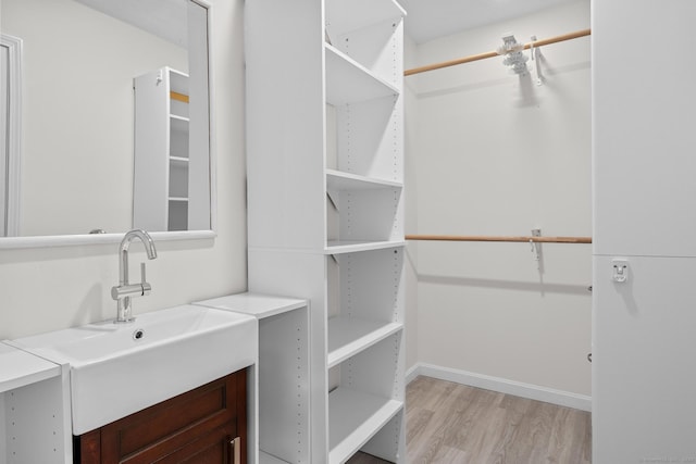 spacious closet featuring sink and light hardwood / wood-style floors