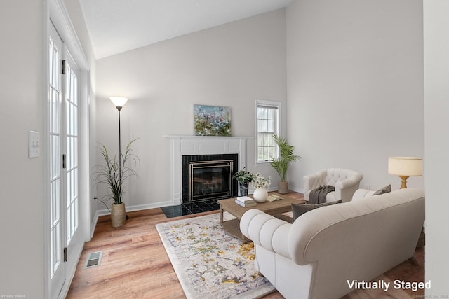 living room with hardwood / wood-style floors and high vaulted ceiling