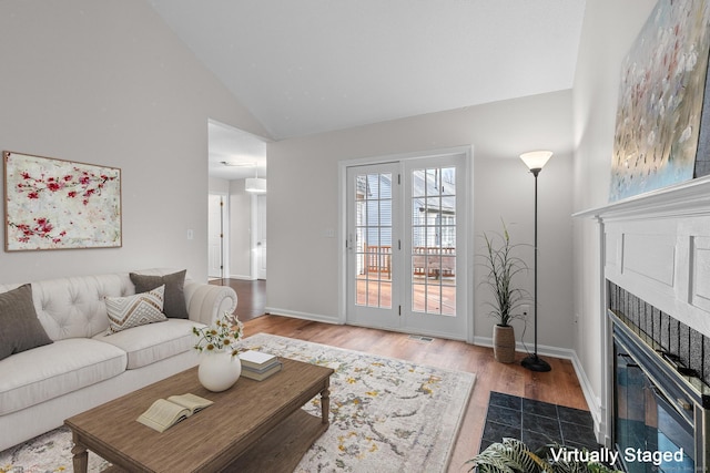 living room featuring light hardwood / wood-style flooring and lofted ceiling