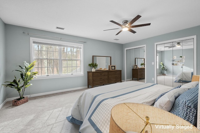 carpeted bedroom featuring ceiling fan and multiple closets