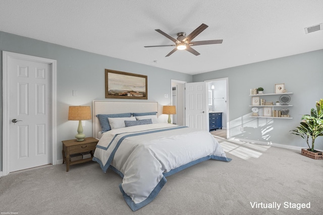 carpeted bedroom featuring a textured ceiling, ceiling fan, and connected bathroom