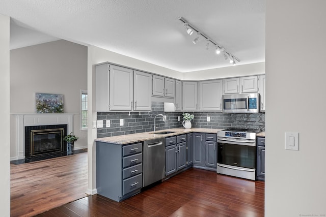 kitchen featuring sink, dark wood-type flooring, appliances with stainless steel finishes, gray cabinetry, and a textured ceiling