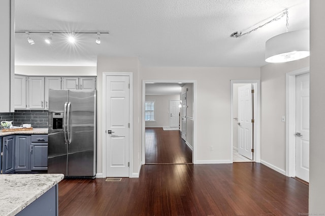 kitchen featuring decorative backsplash, a textured ceiling, dark hardwood / wood-style floors, and stainless steel fridge with ice dispenser