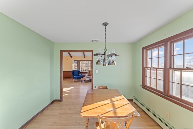 dining room featuring a healthy amount of sunlight, a baseboard radiator, light hardwood / wood-style flooring, and a notable chandelier