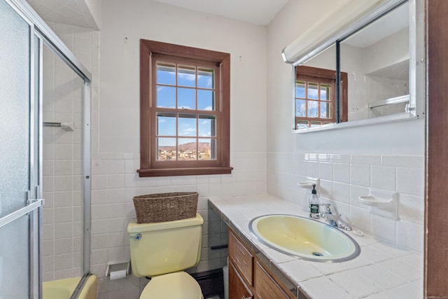 bathroom featuring vanity, toilet, and tile walls