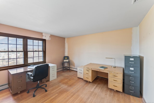 office space featuring light wood-type flooring and a baseboard heating unit