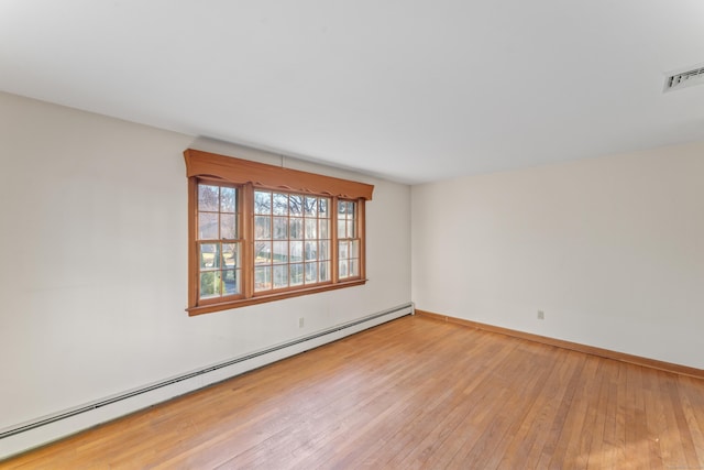 unfurnished room with baseboard heating and light hardwood / wood-style flooring