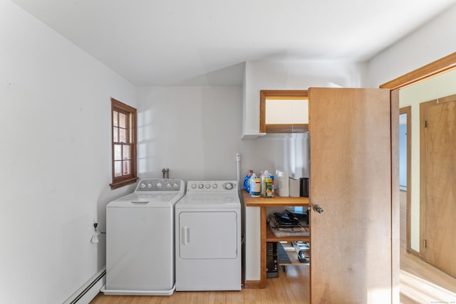 clothes washing area with light wood-type flooring, a baseboard radiator, and washing machine and clothes dryer