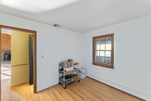 interior space with baseboard heating and light hardwood / wood-style floors