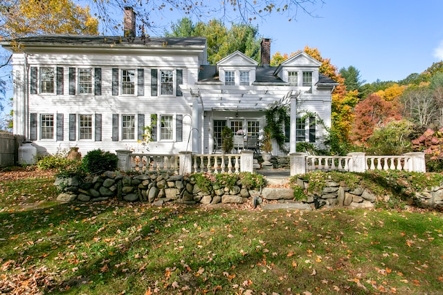 rear view of property featuring a lawn