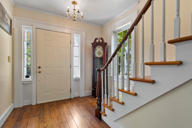 entryway featuring ornamental molding, hardwood / wood-style flooring, and an inviting chandelier