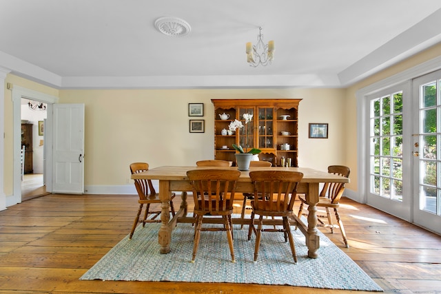 dining area featuring french doors, an inviting chandelier, and hardwood / wood-style floors