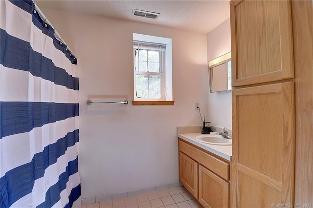 bathroom featuring vanity, tile patterned floors, a textured ceiling, and curtained shower