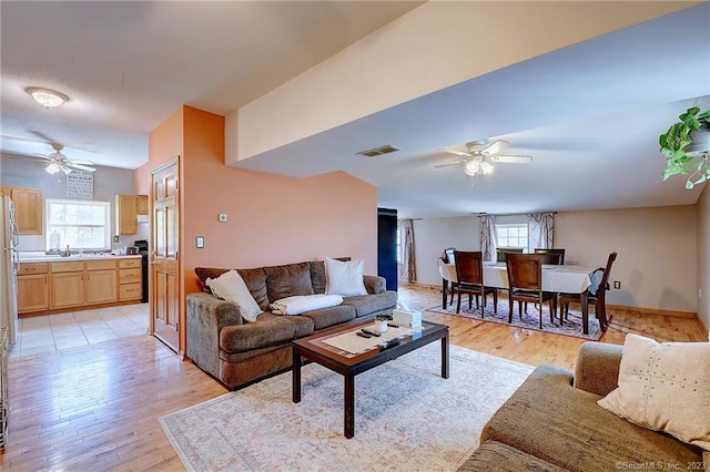 living room featuring light hardwood / wood-style floors, a wealth of natural light, and ceiling fan