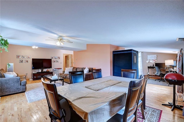 dining space with ceiling fan and light hardwood / wood-style flooring