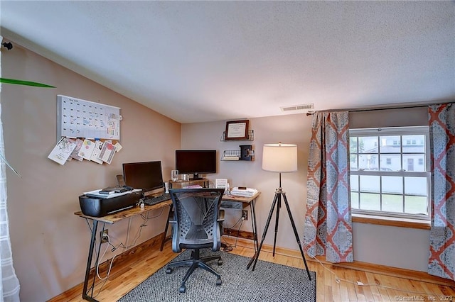 office space featuring a textured ceiling, wood-type flooring, and lofted ceiling