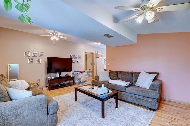 living room featuring vaulted ceiling, light wood-type flooring, and ceiling fan