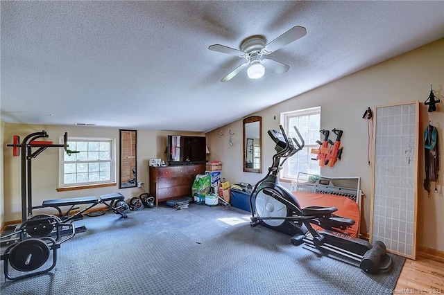 workout area featuring light hardwood / wood-style floors, a textured ceiling, and ceiling fan