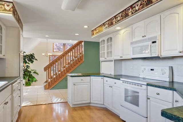 kitchen featuring white cabinetry, an inviting chandelier, tasteful backsplash, light hardwood / wood-style flooring, and white appliances