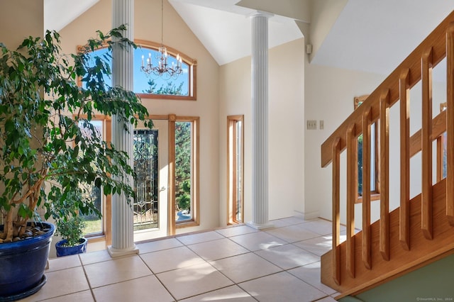 entrance foyer featuring light tile patterned floors, decorative columns, and a healthy amount of sunlight