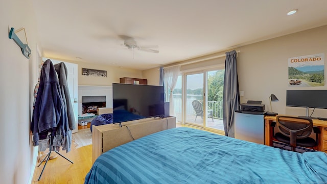 bedroom featuring ceiling fan, access to outside, light wood-style floors, a fireplace, and recessed lighting