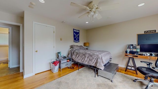 bedroom featuring baseboards, wood finished floors, and recessed lighting