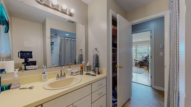 full bath with baseboards, curtained shower, vanity, and finished concrete floors