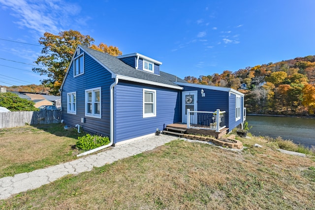 view of front of property featuring a deck with water view and a front yard