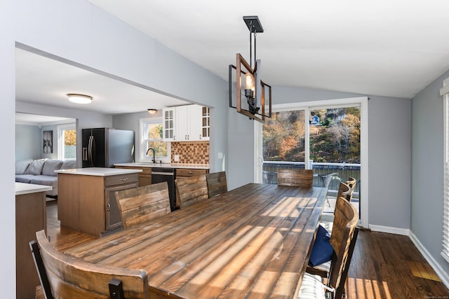 dining space with lofted ceiling, dark hardwood / wood-style floors, and sink