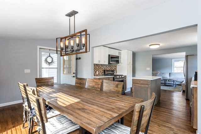 dining area with lofted ceiling, a chandelier, and dark hardwood / wood-style flooring