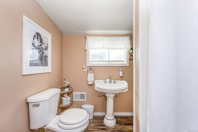 bathroom featuring wood-type flooring, toilet, and a shower with shower curtain