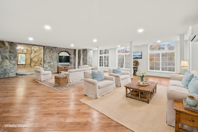 living room featuring light hardwood / wood-style flooring and an AC wall unit