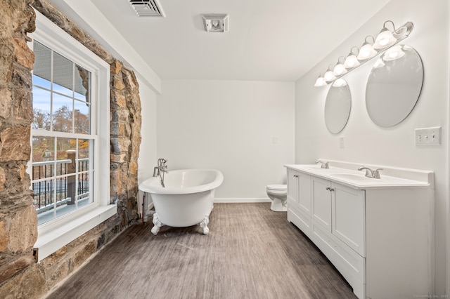 bathroom with toilet, a washtub, vanity, and hardwood / wood-style floors