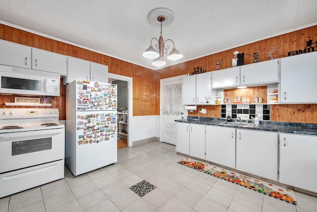 kitchen featuring hanging light fixtures, a notable chandelier, light tile patterned floors, white cabinetry, and white appliances