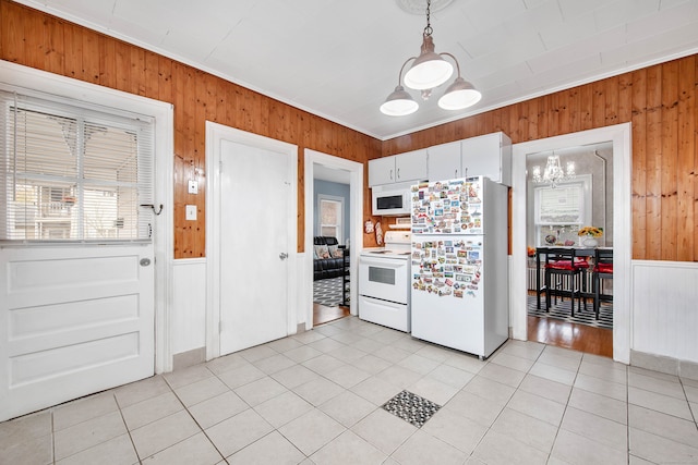 kitchen featuring white appliances, white cabinetry, an inviting chandelier, and pendant lighting