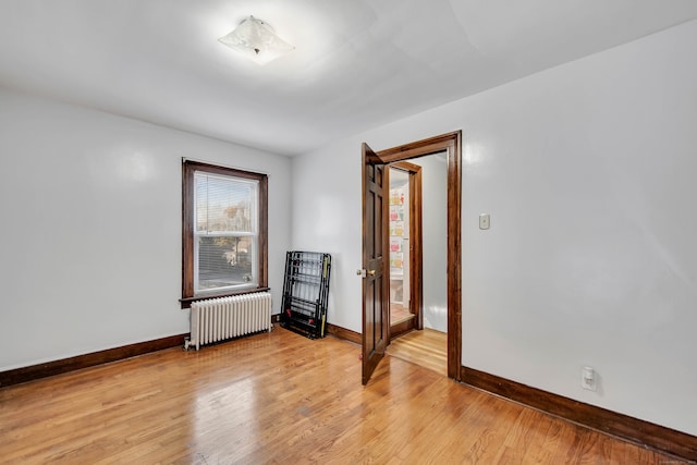 spare room with light hardwood / wood-style floors and radiator heating unit