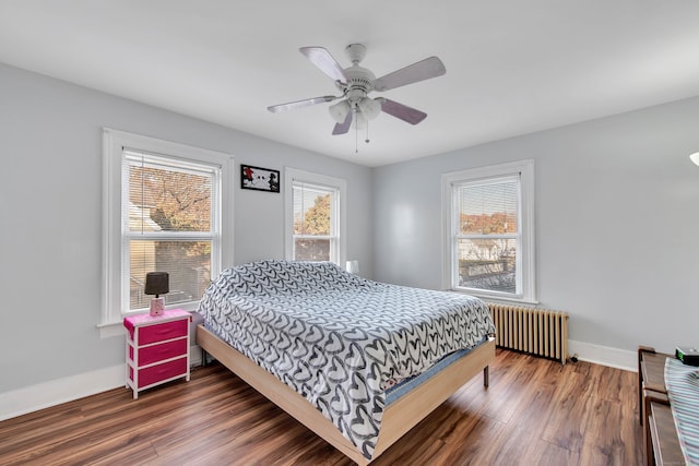 bedroom featuring ceiling fan, radiator heating unit, and dark hardwood / wood-style flooring