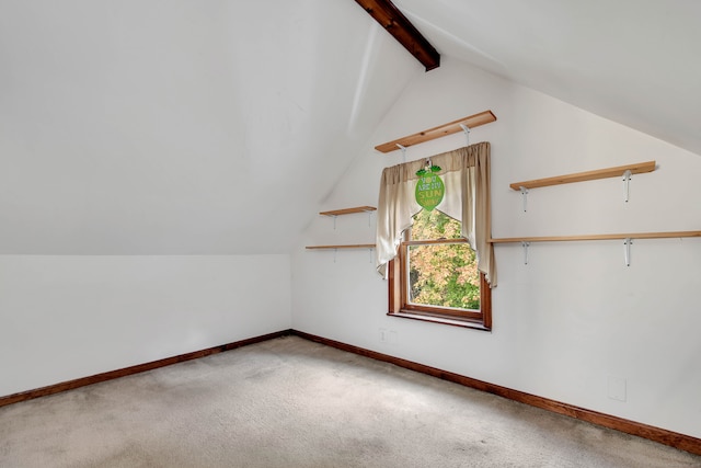 additional living space featuring lofted ceiling with beams and carpet flooring