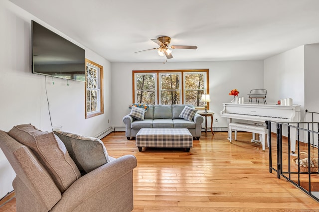 living room featuring a baseboard radiator, light hardwood / wood-style floors, and ceiling fan