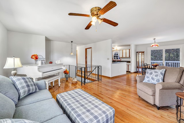 living room with light hardwood / wood-style flooring and ceiling fan